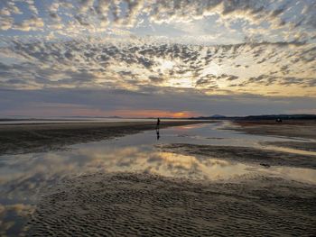 Scenic view of beach against sky during sunset