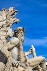 Low angle view of statue against blue sky