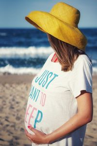 Pregnant woman standing on beach