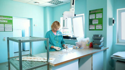 Lab worker studying, examines sprouted, rooted corn seeds, in laboratory. science laboratory