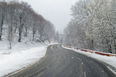 Road passing through snow covered landscape