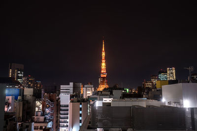 Illuminated buildings against sky at night