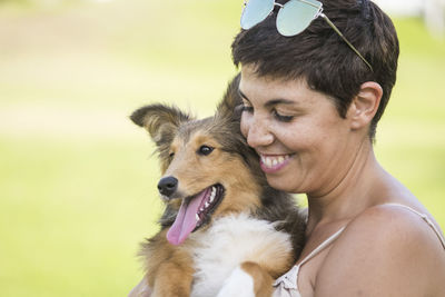 Close-up of smiling woman carrying dog