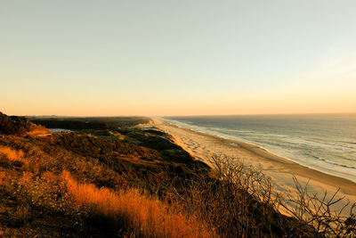 Scenic view of sea against clear sky during sunset