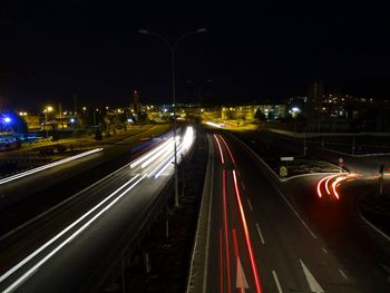 Illuminated light trails on road in city at night