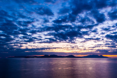 Scenic view of sea against dramatic sky during sunset