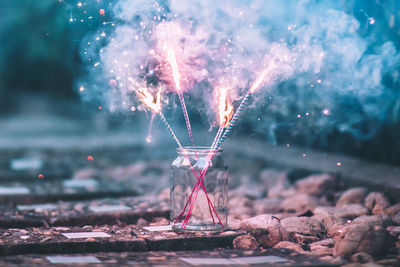 Close-up of illuminated sparkles in jar on railroad track