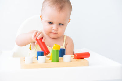 Portrait of cute boy playing with toy blocks on white background