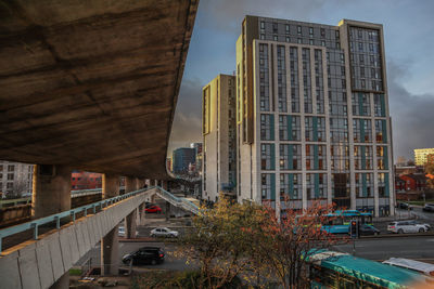 City street by modern buildings against sky