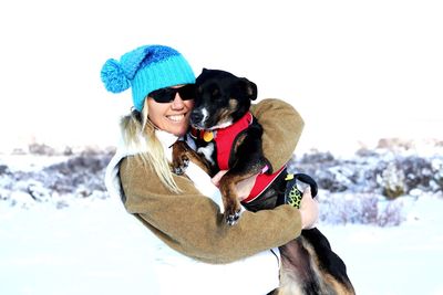 Woman with dog on snow during winter