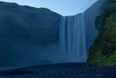 Scenic view of waterfall in mountains