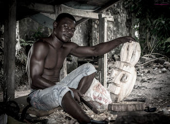 Portrait of mid adult man carving wood at workshop