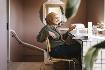 Portrait of young woman sitting in bathroom