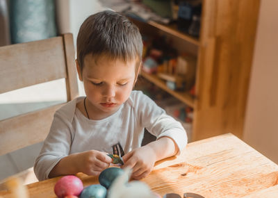 Boy sitting on table at home