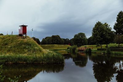 Scenic view of lake by building against sky