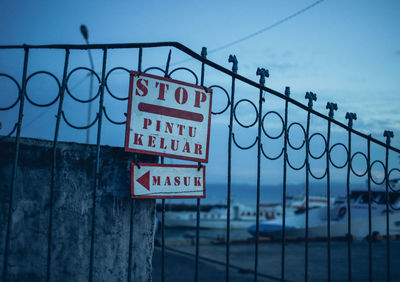 Close-up of sign board against blue sky