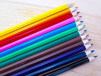 High angle view of colored pencils on wooden table