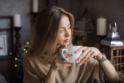 Portrait of young woman drinking coffee cup