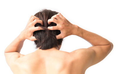 Rear view of shirtless man against white background