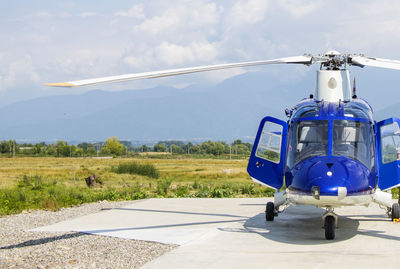 Blue helicopter, view of the plane , sunlight and field