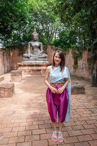 Portrait of smiling woman in traditional clothing standing outdoors