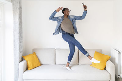 Full length of woman on sofa at home