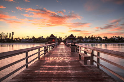 Pier over lake against sky during sunset