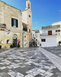 Street amidst buildings in town against clear blue sky