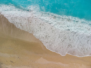 Drone shot of the waves crashing from the beautiful egremni beach in lefkada, greece.