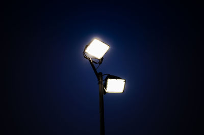 Low angle view of illuminated street light against sky