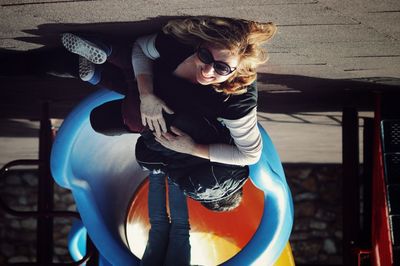 Grandmother with grandson sliding in slide