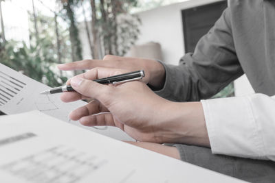 Midsection of man reading book on table