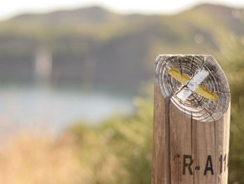 Close-up of text on wooden post trekking