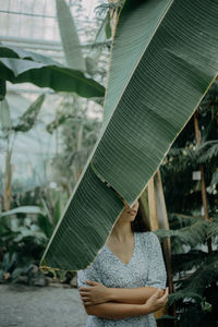 Midsection of woman standing by leaves