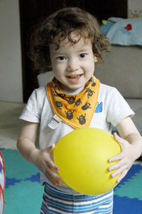 Portrait of cute girl holding balloon at home