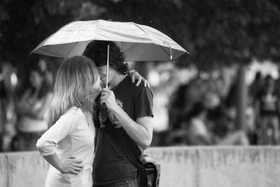 Rear view of man holding umbrella