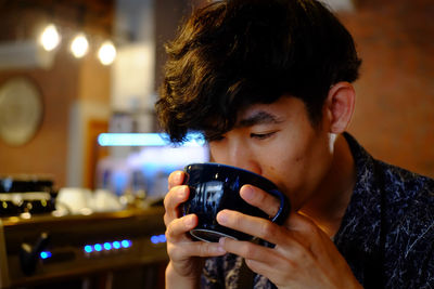 Close-up of man drinking coffee at cafe