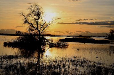 Scenic view of lake against sky at sunset