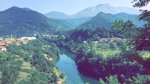 Scenic view of river amidst mountains against sky