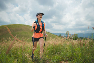 Full length of woman standing on field against sky