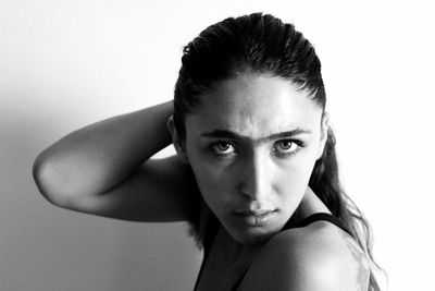 Close-up portrait of young woman against white background