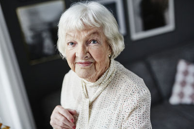 Portrait of smiling woman sitting at home