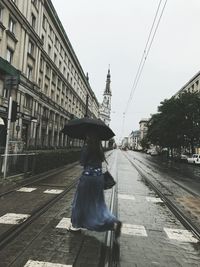 Man standing on railroad track against sky