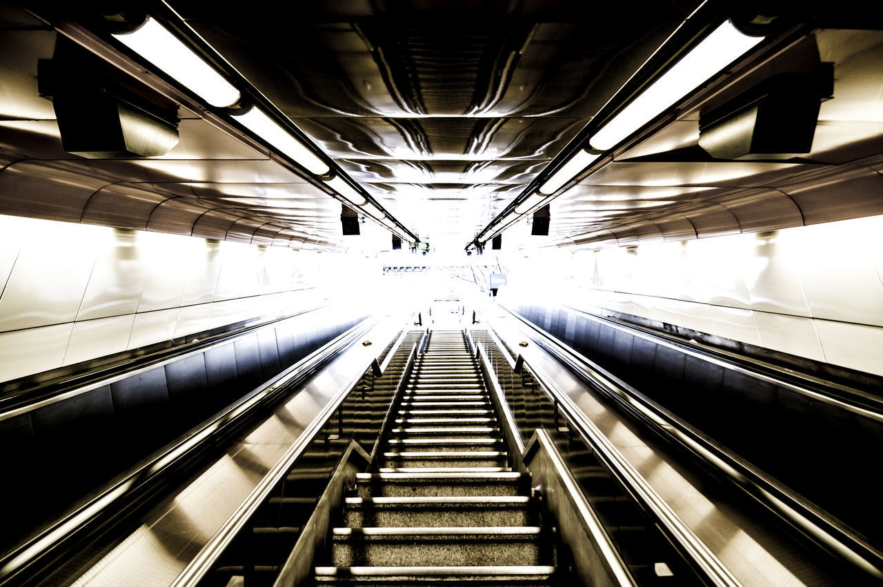 LOW ANGLE VIEW OF ESCALATOR IN ILLUMINATED UNDERGROUND