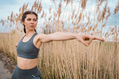 Determined woman doing yoga by field