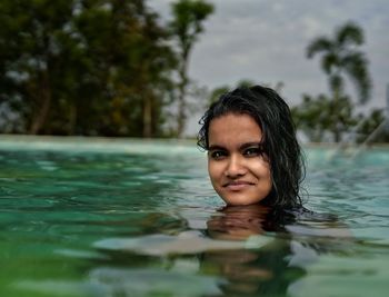 Portrait of smiling woman swimming in pool