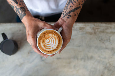 Midsection of man holding coffee cup