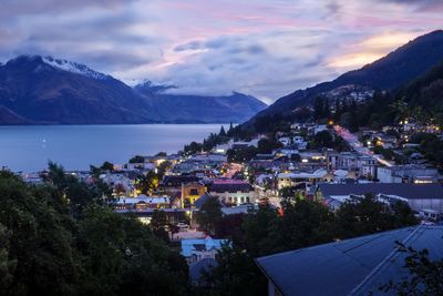 High angle view of townscape by sea against sky at dusk