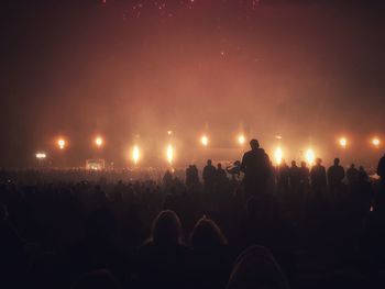 Crowd at music concert against sky at night