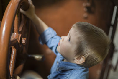 High angle view of toddler with steam train wheel